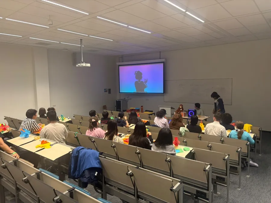 International students crafting paper lanterns during a cultural evening in a lecture hall